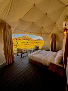 a bedroom with a bed in a tent with a view at Montana Camp wadi rum in Wadi Rum