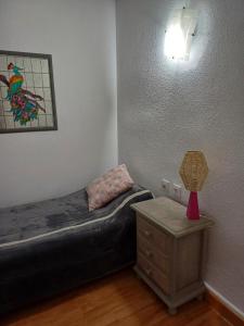 een slaapkamer met een bed en een tafel met een lamp bij REX CUATRO in Benidorm