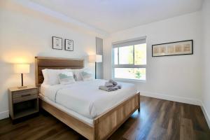 a white bedroom with a large bed and a window at Los Angeles Premium City Suites with Free Parking in Los Angeles