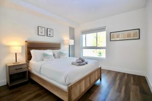 - une chambre blanche avec un grand lit et une fenêtre dans l'établissement Los Angeles Premium 2BR&2BT Suites with Free Parking, à Los Angeles
