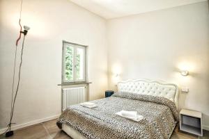 a white bedroom with a bed and a window at Villa Giuliana in Arezzo