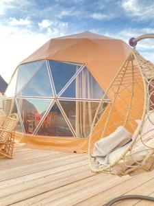 uma tenda cúpula num deque com uma cadeira em Montana Camp wadi rum em Wadi Rum