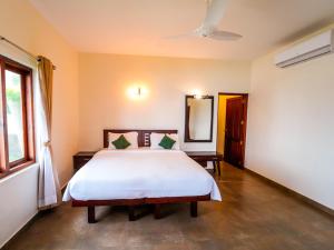 a bedroom with a bed and a mirror at Solaris Varkala Beach Resort By VOYE HOMES in Varkala