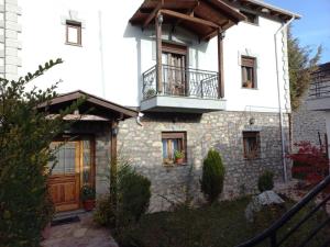 Dieses weiße Haus verfügt über einen Balkon und eine Veranda. in der Unterkunft Vila Mata in Voskopoja