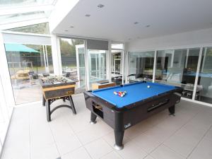 een pooltafel in een kamer met glazen wanden bij Splendid villa in Flemish Ardennes with pool in Zottegem