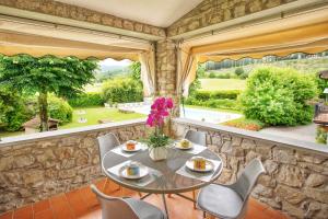 ein Esszimmer mit einem Tisch und Stühlen sowie einem großen Fenster in der Unterkunft Villa Giuliana in Arezzo