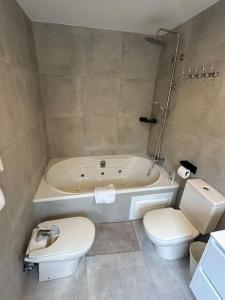 a bathroom with a tub and a toilet and a sink at Gavà Mar: Villa Lujo 6 Pax in Gavà