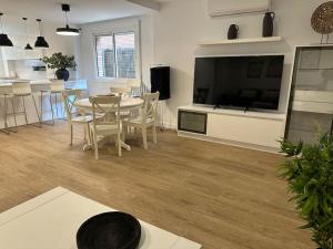 a living room with a table and a large television at Gavà Mar: Villa Lujo 6 Pax in Gavà