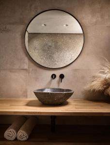 a bathroom with a bowl sink and a mirror at Ananta Blue Residence in Argassi