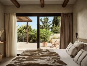 a bedroom with a bed and a large window at Ananta Blue Residence in Argassi
