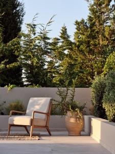 凱勒西的住宿－阿南塔藍色公寓，坐在种植了盆栽植物的庭院里的椅子