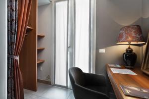 um quarto com uma secretária, uma cadeira e uma janela em CasaDodici Boutique Hotel em Cesenatico