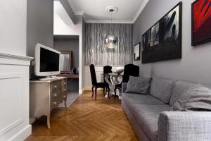 a living room with a couch and a table with a television at CasaDodici Boutique Hotel in Cesenatico