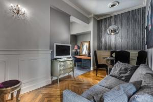 a living room with a couch and a tv at CasaDodici Boutique Hotel in Cesenatico