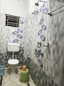 a bathroom with a shower with a toilet in it at Veda Homestay in Agartala