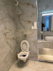 Un baño con inodoro y una persona tomando una foto. en Apparemment colombes, en Colombes