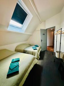 2 camas en una habitación pequeña con ventana en Chambres d’hôtes autonomes le domaine Neuf Morlac, en Morlac