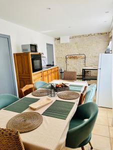 Habitación con mesa, sillas y cocina. en Chambres d’hôtes autonomes le domaine Neuf Morlac, en Morlac
