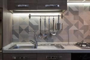 a kitchen sink with utensils on a wall at La Casa dei Nonni in Isola del Gran Sasso dʼItalia +42 photos