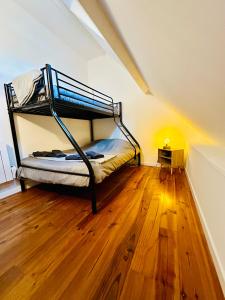 1 dormitorio con litera en el suelo de madera en Chambres d’hôtes autonomes le domaine Neuf Morlac, en Morlac