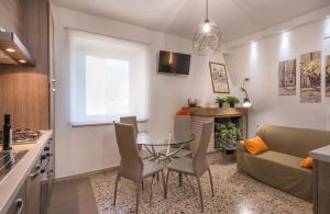 uma cozinha e sala de estar com uma mesa de vidro e cadeiras em La Casa dei Nonni em Isola del Gran Sasso dʼItalia