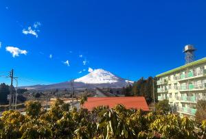 vista su una montagna innevata con un edificio di 富士見の宿 a Gotemba