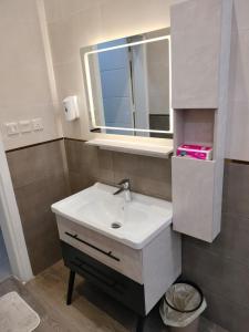uma casa de banho com um lavatório branco e um espelho. em فلل الكناري الراقية em Taif