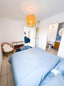 sypialnia z dużym niebieskim łóżkiem i krzesłem w obiekcie LE COSY LODGE 2.0 *** Swimming pool and Calm w mieście Cusset