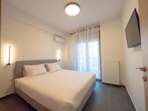 a bedroom with a white bed and a window at Trikala Leisure in Tríkala