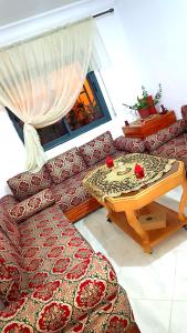 ein Wohnzimmer mit einem Sofa und einem Tisch in der Unterkunft Dar Shama - Women only in Rabat