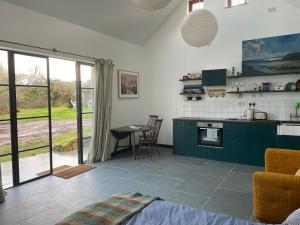 een keuken met groene kasten en een tafel bij Tresahor Studio in Falmouth