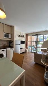 a kitchen with white appliances and a table with chairs at L'écrin du Cap Esterel in Saint-Raphaël