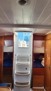 Habitación pequeña con 2 camas y ventana en un yate en Velero Beneteau Cyclades 43.4, en Palma de Mallorca