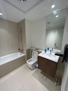La salle de bains est pourvue d'une baignoire, de toilettes et d'un lavabo. dans l'établissement Cozy beautiful apartment Al zahia mall, à Charjah