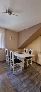 a dining room with a white table and chairs at Apartmaji Medved, brezplačno parkiranje in Tacen