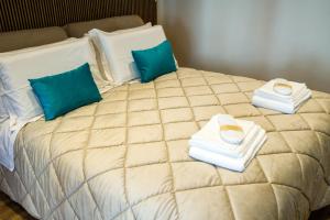 een bed met twee handdoeken en twee kussens erop bij BAYRIA HOME in Bari