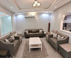 ein großes Wohnzimmer mit Sofas und einem Tisch in der Unterkunft فلل الكناري الراقية in Ta'if