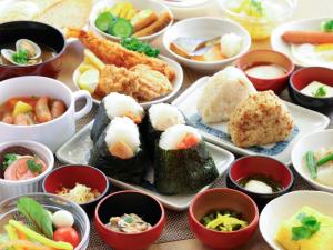 a table topped with plates of sushi and bowls of food at Dormy Inn Ueno Okachimachi in Tokyo