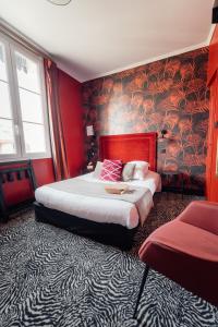 a bedroom with a large bed with red walls at La villa 10 HÔTEL SPA in Étretat