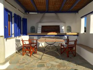 tavolo e sedie in una stanza con finestre blu di Beach Lodge Paros @ Kite Beach a Pounda