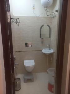 a small bathroom with a toilet and a sink at Kalash Guest House in Ayodhya