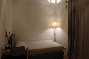a small bedroom with a bed and a lamp at Cosy room near Berlin and close to Tesla Factory in Brandenburg 