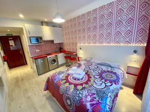 a small room with a bed and a kitchen at MuchoMadrid Apartments in Madrid