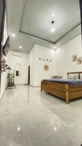 1 dormitorio con 1 cama en una pared blanca en Juliana HomeStay, 