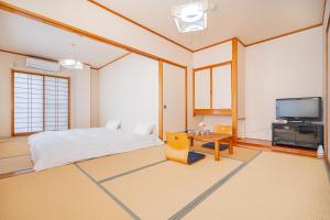a bedroom with a bed and a tv at 富士見の宿 in Gotemba