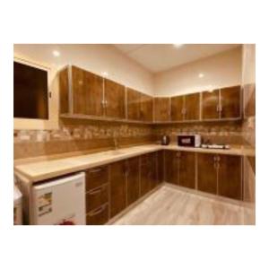 a kitchen with wooden cabinets and a counter top at Diamond suites in Al Madinah