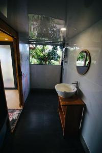 a small bathroom with a sink and a mirror at Bình An lake view in Buon Ma Thuot
