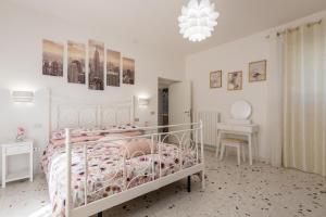 a bedroom with a white bed and a chandelier at La Casa dei Nonni in Isola del Gran Sasso dʼItalia