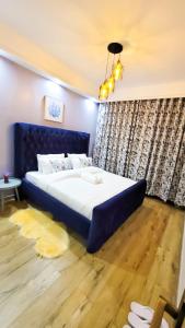 ナイロビにあるGoldpark apartmentsのベッドルーム1室(大型ベッド1台、青いヘッドボード付)