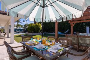 - une table à manger avec un parasol sur la terrasse dans l'établissement Villa Del Sol, à Palm Springs